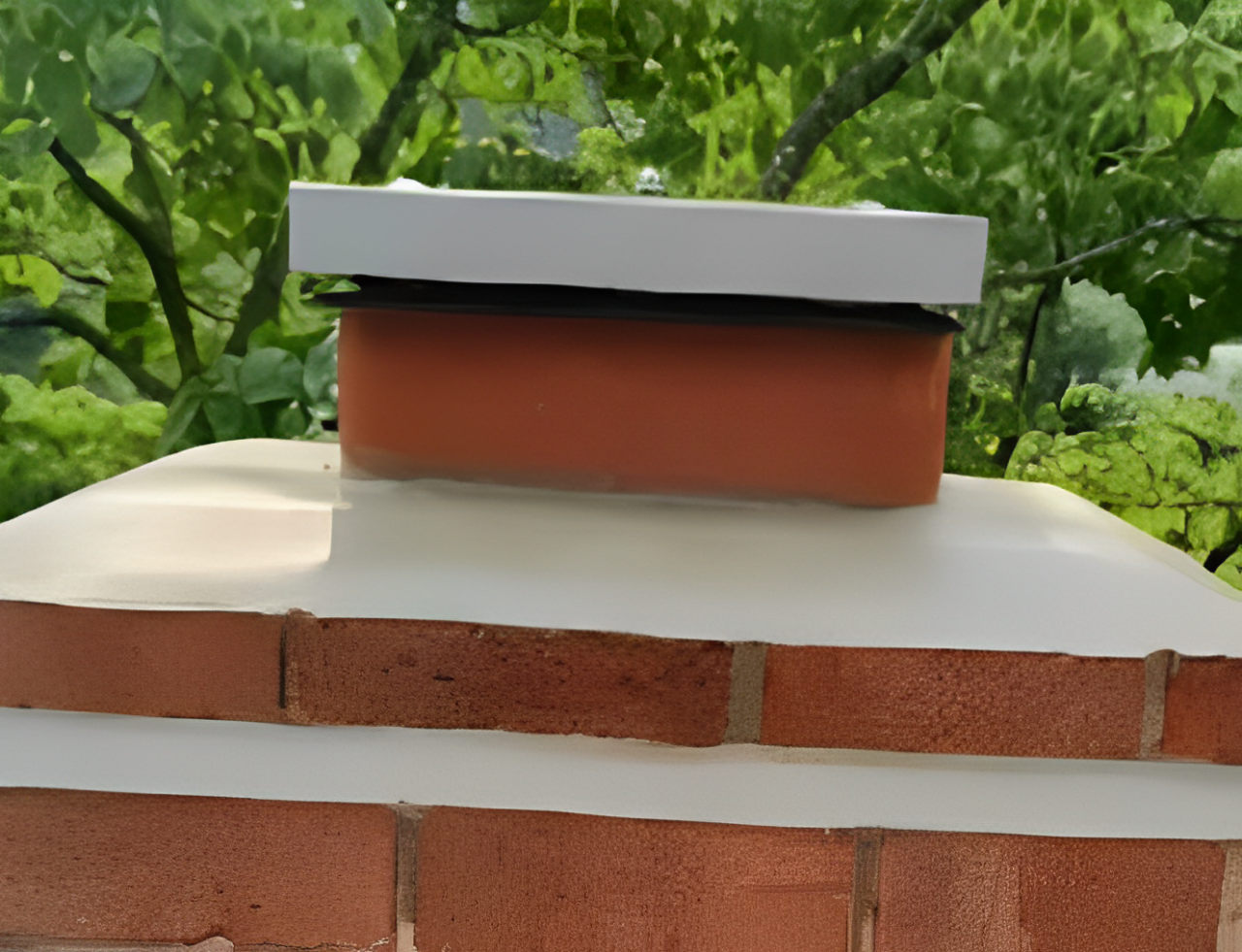 A brick chimney with a box on top of it.